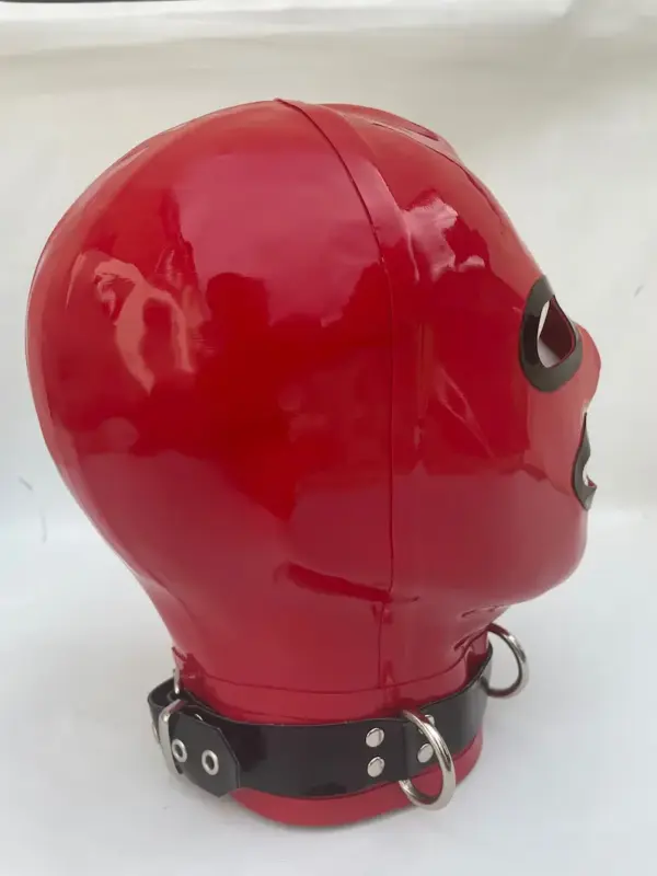 Side view of red rubber bondage mask showing metal D-rings
