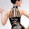 Model wearing elegant rubber harness top showing strappy collar design and dual snap buttons