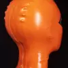 Side view of vibrant orange rubber fox mask with back zipper