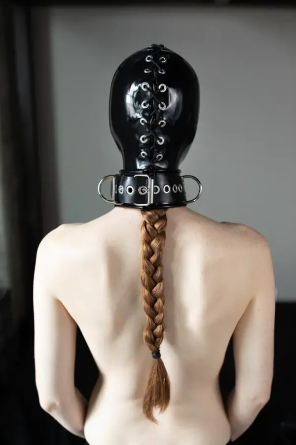 Rear view of laced back rubber bondage mask with metal O-rings