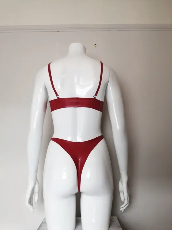 Mannequin wearing pastel and red rubber fetish lingerie set showing adjustable straps and high cut fit