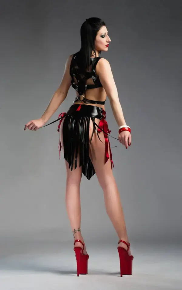 Model wearing cutout rubber tassel skirt showing adjustable side ribbons and flowing fringe panels