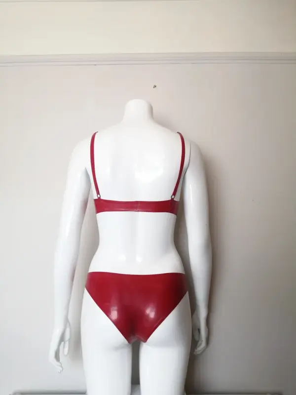 Model wearing classic red rubber fetish two piece set showing supportive round cups and adjustable straps